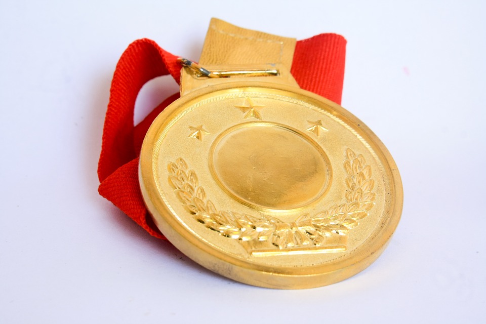 goldene Medaille mit rotem Band