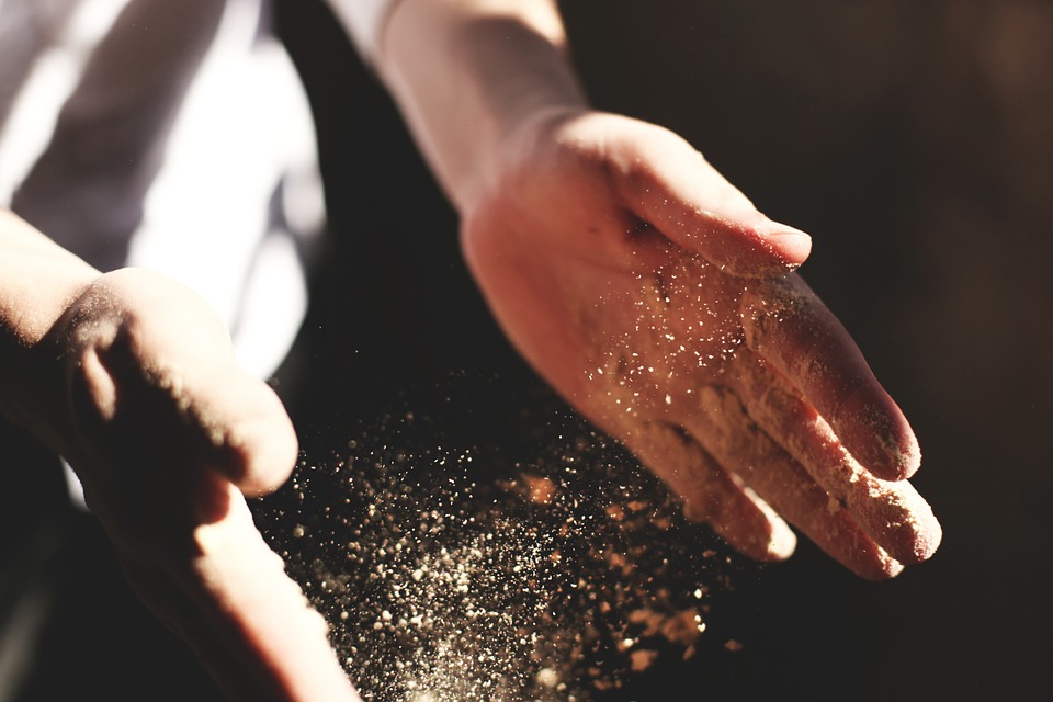 klatschende Hände mit Sand