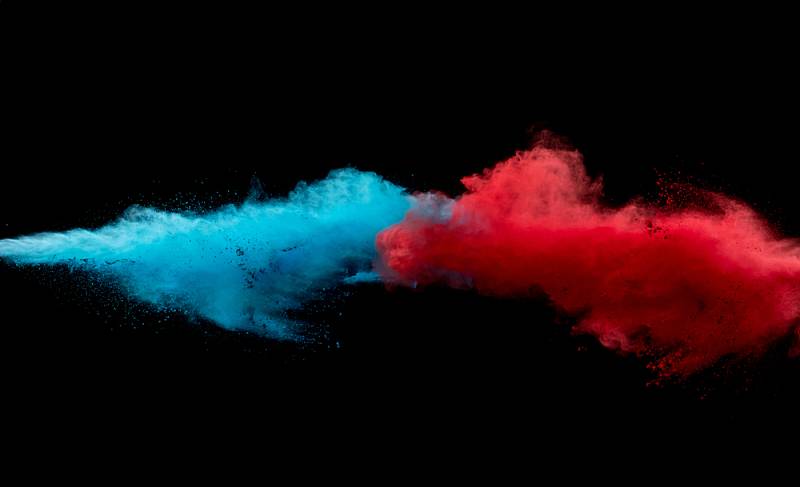 Symbolbild: eine blaue (links) und eine rote (rechts) Wolke treffen in der Mitte des Bildes aufeinander.