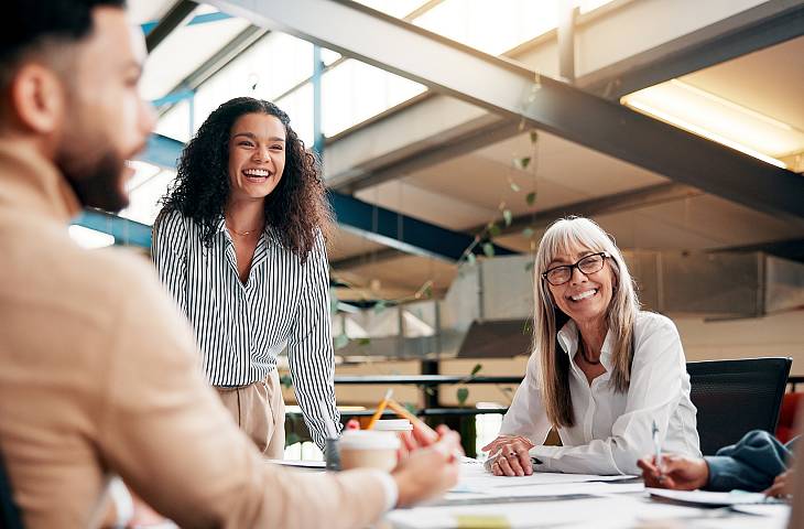 Junge Frau die vor einem Team steht und einen Vortrag hält.