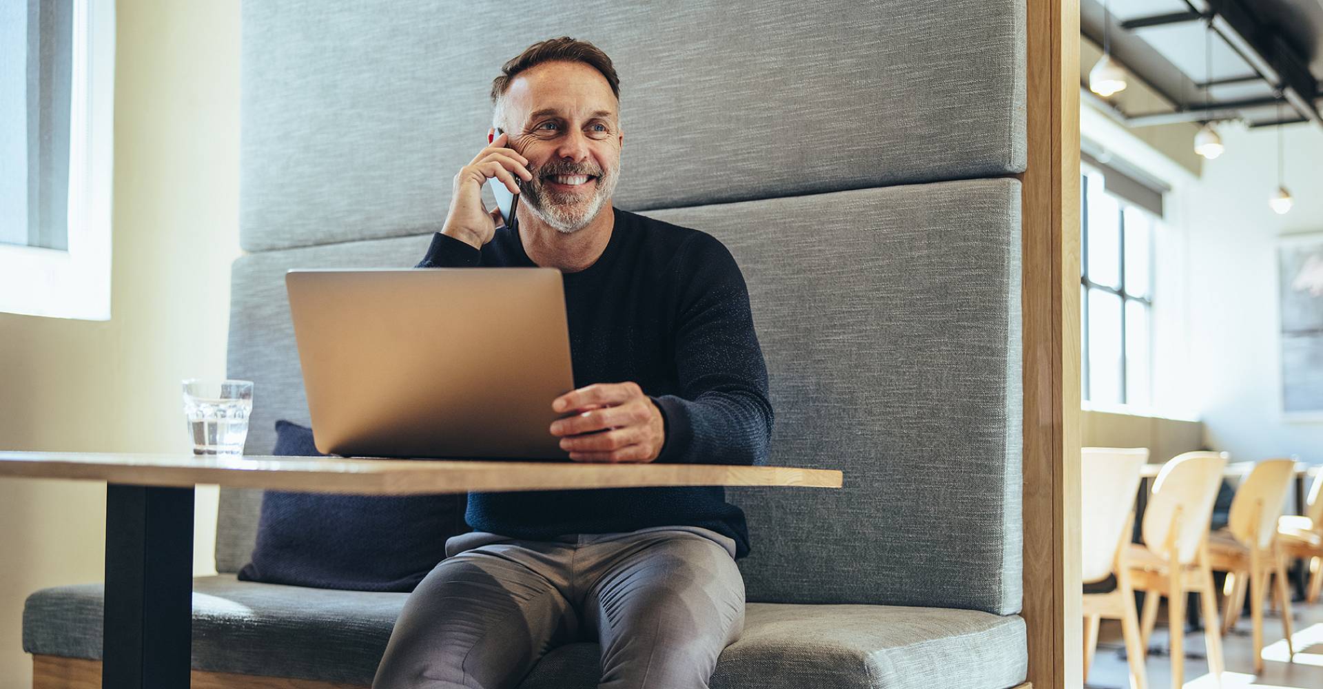 Moderne Atmosphäre mit einen Geschäftsführer der am Laptop sitzt und telefoniert