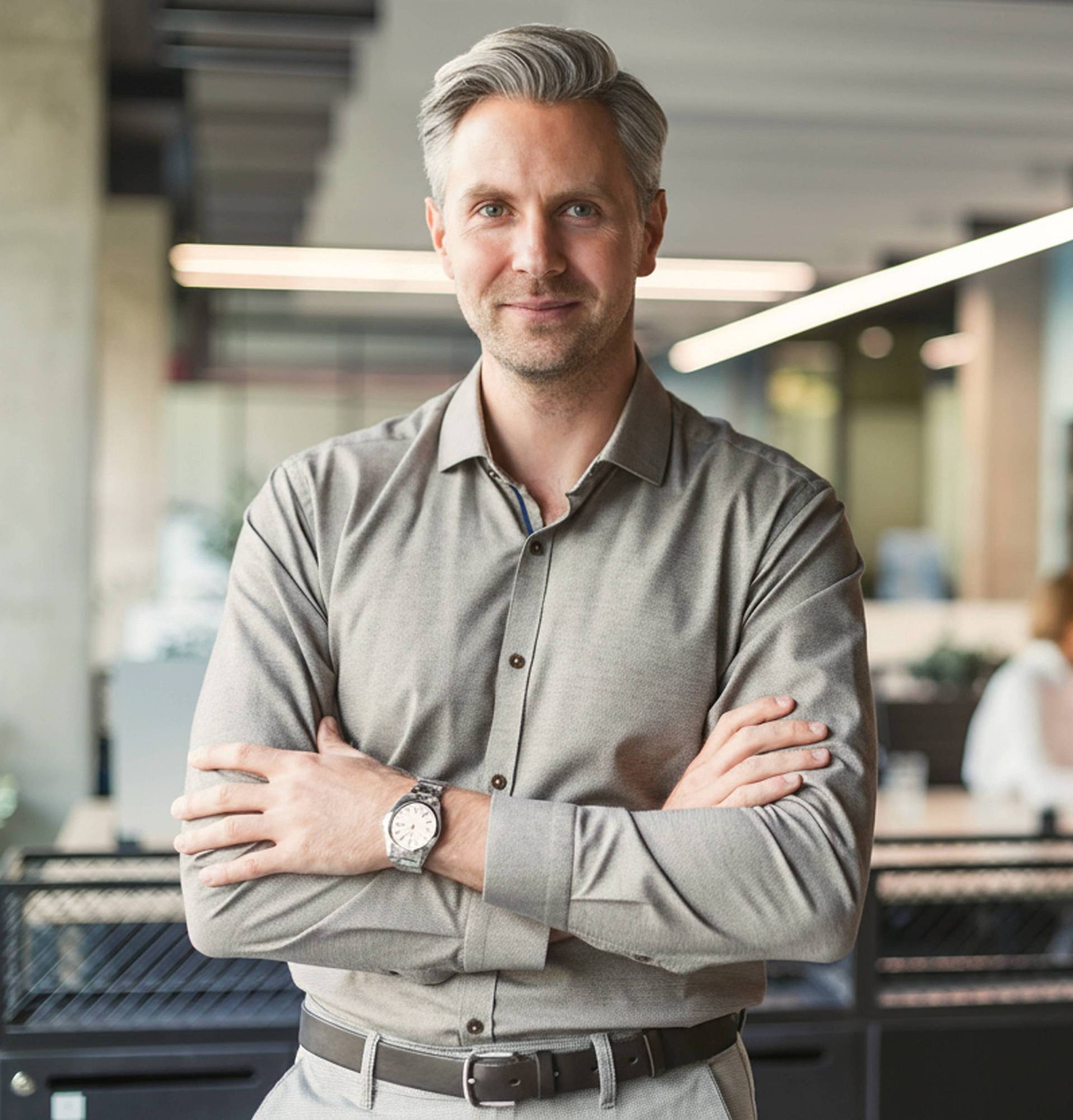 Geschäftsführer steht im Büro und blickt in die Kamera. Modernes Büro.