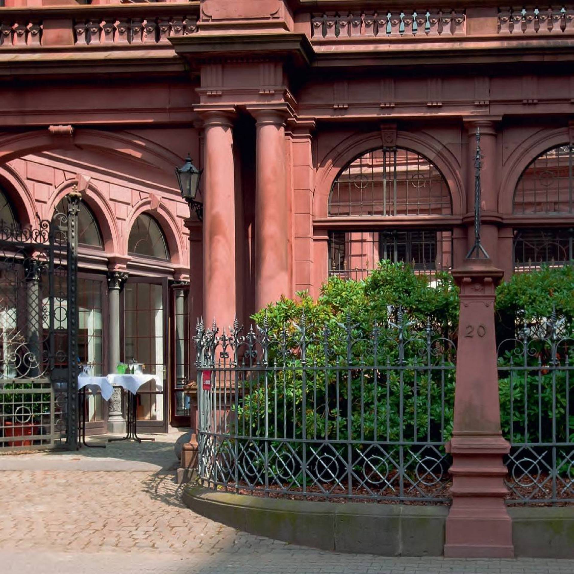 Historische Außenfassade des Frankfurter PresseClubs mit rotem Sandstein, verzierten Fenstern und schmiedeeisernem Zaun im Vordergrund