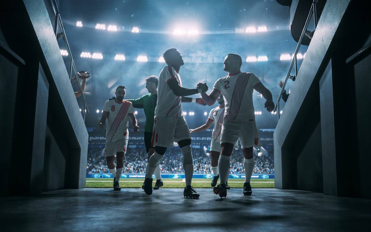 Fußballmannschaft läuft gemeinsam aufs Spielfeld und feiert den Teamgeist.